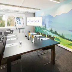 Nowoczesna sala konferencyjna Novotel z malowniczą wizualizacją dla dorosłych na ścianie.