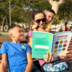 Mama z synami czyta książkę "Emocje: wszystko, co czujesz". To 6 buław uczucia, które pomagają zrozumieć dziecięce emocje.
