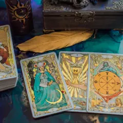 Tarot byk miesięczny: talia kart z wizerunkami postaci i symboli, w tym karta z bykiem, świeca, skrzynia i pióro.