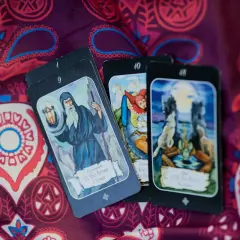 Tarot a zdrowie: karty z wizerunkiem pustelnika, koła fortuny i księżyca na wzorzystym tle.