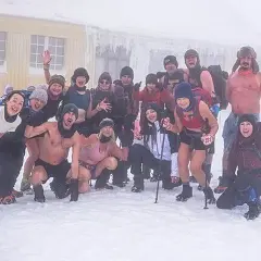 Grupa entuzjastów morsowania w stylu Wim Hof Polska pozuje do zdjęcia na mrozie.