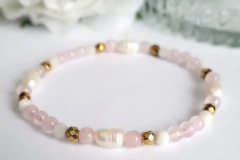 Delikatna bransoletka z koralików kwarc różowy, pereł i złotych elementów. Symbol miłości i harmonii.