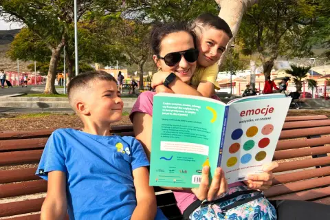 Mama z synami czyta książkę "Emocje: wszystko, co czujesz". To 6 buław uczucia, które pomagają zrozumieć dziecięce emocje.