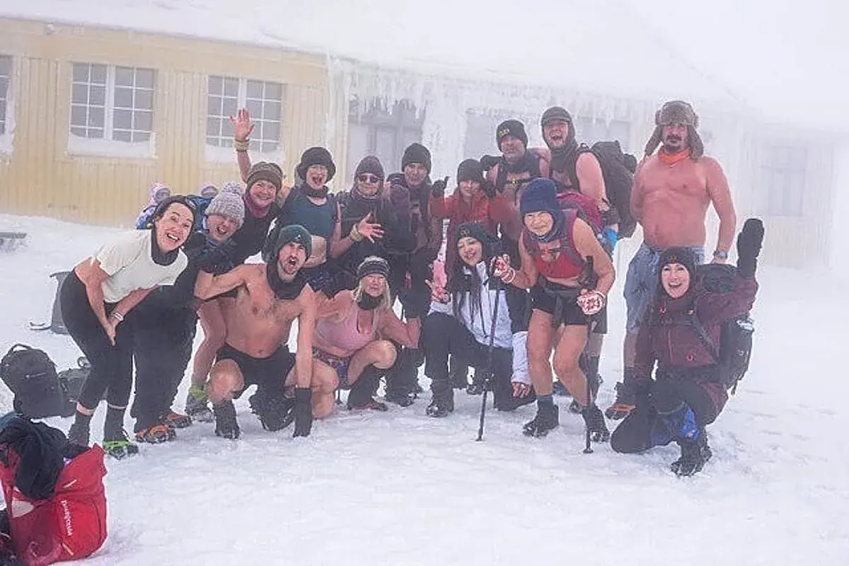 Grupa entuzjastów morsowania w stylu Wim Hof Polska pozuje do zdjęcia na mrozie.